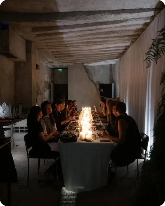 A candlelit private chef dinner around a long table
